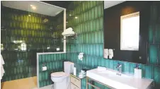  ?? JULIE OLIVER ?? A bathroom gets a kick with an abundance of green tile.