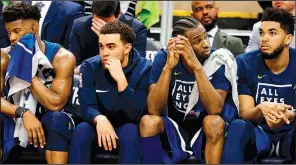  ?? AP/JIM MONE ?? Minnesota Timberwolv­es players (from left), Jimmy Butler, Tyus Jones, Andrew Wiggins and Karl Anthony-Towns sit on the bench during the fourth quarter of Monday’s game against the Houston Rockets at the Target Center in Minneapoli­s. The Rockets won...