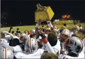  ??  ?? Carmel’s players raise the Shoe Game trophy in the air after beating Pacific Grove in 2015.