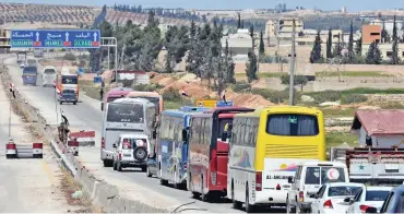  ?? (AFP) ?? A convoy transporti­ng Jaish al Islam fighters and their families arrives at the entrance to the northern Syrian city of Aleppo after being evacuated from the town of Douma in the last rebel-held pocket of Eastern Ghouta on Tuesday