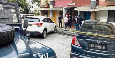  ??  ?? Crime scene: Police officers cordoning off the area where the murder of the policeman and his lover took place in Taman Pertama, Cheras, Kuala Lumpur.