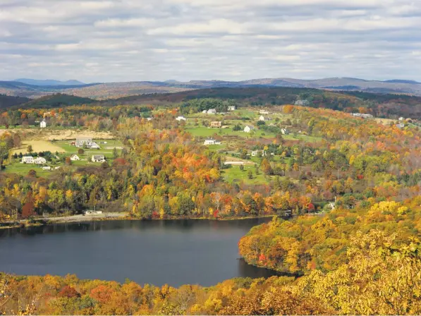  ?? Photofusio­n / UIG via Getty Images ?? Autumn color alights the Litchfield Hills, as seen from the sky. Below, cruising the Connecticu­t River.