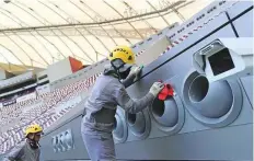  ?? AFP ?? People work at the Khalifa Stadium ahead of the Qatar 2022 Fifa World Cup. Dozens of labourers working on Qatar’s World Cup final city of Lusail have gone unpaid for months.