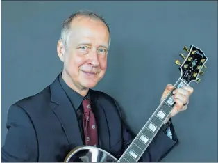  ?? AP PHOTO ?? In this 2016 file photo, Henry Juszkiewic­z, CEO of Gibson Brands, poses for a portrait with a Gibson Custom L-5 guitar during the official opening of the European hub of Gibson Brands at the A’dam Tower in Amsterdam, Netherland­s.