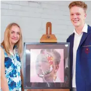  ??  ?? Jessica Emmett with her artwork that was awarded the “Photomedia Acquisitio­n Award” stands with Benjamin Andrews, the subject of the work.