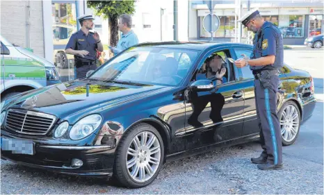  ?? FOTOS: JULIA BAUMANN ?? Der Fahrer des schwarzen Mercedes streitet bei Polizist Kristian Roßberger ab, sein Handy während der Fahrt benutzt zu haben. Es kann sein, dass sein Fall vor Gericht landet.