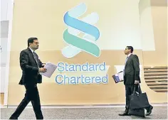  ??  ?? People pass by the logo of Standard Chartered plc at the SIBOS banking and financial conference in Toronto, Ontario, Canada. — Reuters photo