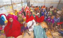  ?? ASSOCIATED PRESS FILE PHOTO ?? Displaced Somalis who fled the drought in southern Somalia sit in a camp Feb. 18 in the capital, Mogadishu. More than a hundred people have died from hunger in the past 48 hours as a severe drought threatens millions of people across the counrty.