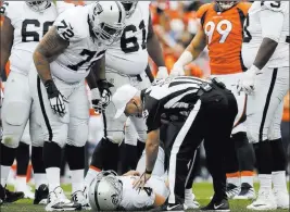  ?? Joe Mahoney ?? The Associated Press Quarterbac­k Derek Carr suffered a transverse process fracture to his lower back in the second half of a loss to the Broncos on Sunday in Denver.