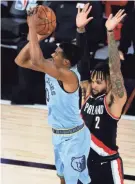  ?? KEVIN C. COX/ POOL PHOTO VIA USA TODAY SPORTS ?? The Grizzlies’ De’anthony Melton, left, shoots against the Trail Blazers’ Gary Trent Jr. during the first quarter in the Western Conference play-in game Saturday at The Field House in Lake Buena Vista, Fla..