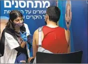  ?? Maya Alleruzzo Associated Press ?? MORE THAN 3 million of Israel’s 9 million citizens have gotten a third dose of the Pfizer vaccine. Above, a man receives a booster shot in Jerusalem in August.