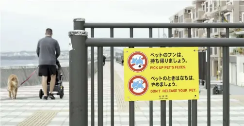  ?? The Yomiuri Shimbun ?? Signs in Japanese and English remind people how to manage their pets in Chatan, Okinawa Prefecture, on March 22.