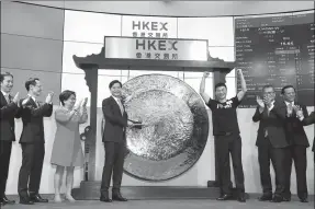  ?? ROY LIU / CHINA DAILY ?? Lei Jun, chairman and CEO of Xiaomi, strikes a gong to mark the trading debut of the company’s shares on Monday at the Hong Kong stock exchange.