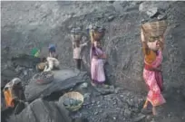  ??  ?? People carry baskets of coal scavenged illegally at an openpit mine in the village of Bokapahari in 2011.