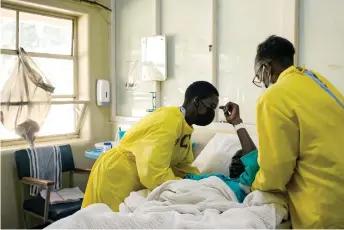  ?? ?? Nurses attend to a patient lying on a hospital bed in a medical ward at a local hospital in Harare.