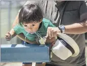  ?? Mel Melcon Los Angeles Times ?? KEEPING children hydrated is vital. Here, Abe Perez helps his son Mavy, 2, at a Canoga Park fountain.