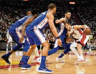  ?? MARK BROWN / GETTY IMAGES ?? Miami’s Goran Dragic (right) drives against Philadelph­ia’s Ben Simmons as Joel Embiid (left) and Justin Anderson (second from left) defend during the Heat’s loss on Saturday.