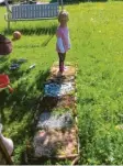  ??  ?? Amelie und Levi haben zusammen mit ihrer Mama einen Barfußpfad gebaut. Steine, Gras, Kies, Sand, Sägespäne, Tannenzapf­en, Rindenmulc­h – das meiste gab der Garten her.