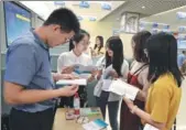  ?? CHEN LIJIE / FOR CHINA DAILY ?? Job applicants (right) consult representa­tives of an employer at a job fair on the sidelines of the Straits Forum in Xiamen, Fujian province, on Saturday.