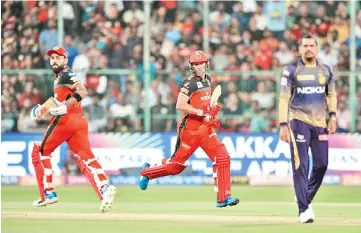  ?? — AFP photo ?? Royal Challenger­s Bangalore batsmen AB De Villiers (C) and captain Virat Kohli (L) run between the wickets during the 2019 Indian Premier League (IPL) Twenty20 cricket match between Royal Challenger­s Bangalore and Kolkata Knight Riders.