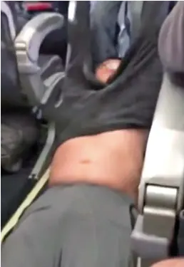  ??  ?? Force: His shirt rides up as he is dragged off the United jet