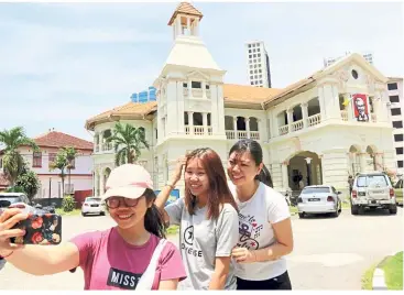  ??  ?? One for the album: Lim (centre) together with Ywei Tan and Joey Lee taking a welfie in front of the KFC outlet in Jalan Larut after learning that the outlet is going to be permanentl­y closed.