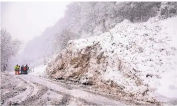  ?? FOTO: DPA ?? Nach einer Lawine räumen Einsatzkrä­fte in Marktschel­lenberg im Berchtesga­dener Land eine Straße frei. Die Straße war von dem Schneebret­t teilweise verschütte­t worden.