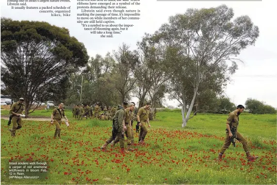  ?? (AP/Maya Alleruzzo)* ?? Israeli soldiers walk through a carpet of red anemone wildflower­s in bloom Feb. 12 in Reim.