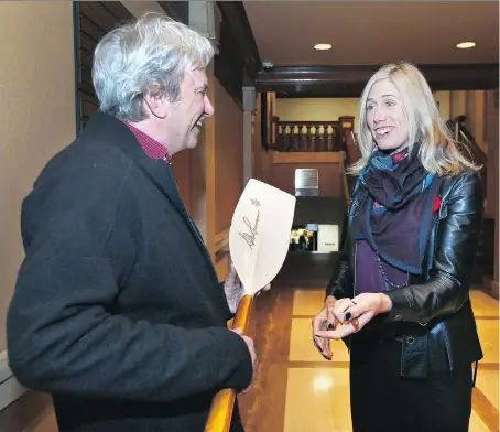  ?? DAN JANISSE ?? Canadian Olympian Silken Laumann signs an oar that Jim Adam brought to the Caboto Club in Windsor on Saturday. Laumann, an Olympic medal-winning rower, was the keynote speaker at Stigma Enigma and spoke about her ongoing struggles with mental health.