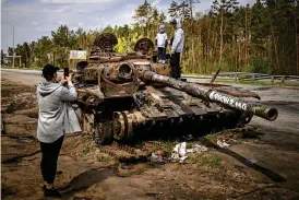  ?? EMILIO MORENATTI / ASSOCIATED PRESS ?? Maksym, 3, is photograph­ed with his brother, Dmytro, 16, on top of a destroyed Russian tank, on the outskirts of Kyiv, Ukraine, on Sunday.