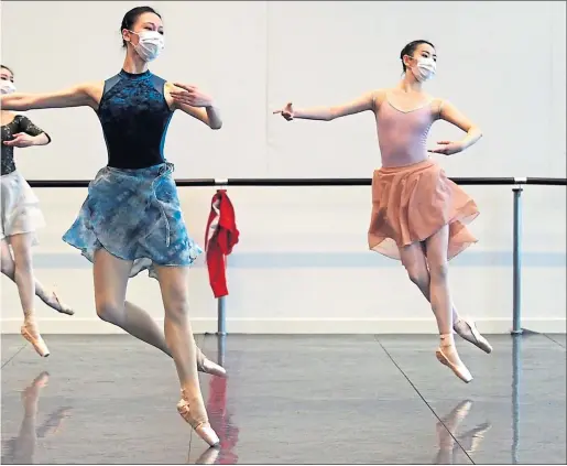  ??  ?? A masked ballet troupe live stream a performanc­e in Shanghai yesterday as a course was moved online due to the virus outbreak