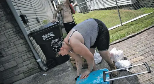  ??  ?? Brittany Cunningham 31, fills her suitcase with food donations accompanie­d by her fiance in Nelsonvill­e, Ohio, on July 24. Cunningham, a heroin addict, has been homeless for 10 years.