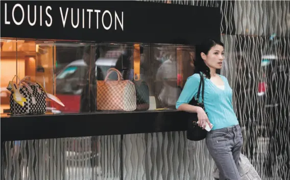  ?? Anthony Wallace / AFP / Getty Images 2013 ?? Although places like Louis Vuitton still pamper shoppers in stores, many customers in China are doing more of their luxury shopping online.