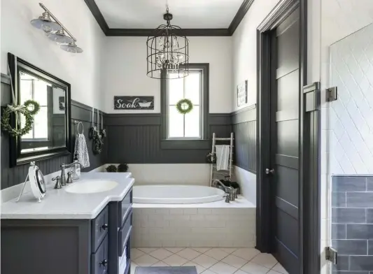  ??  ?? (top) The original master bathroom was a dingy yellow. “I decided to go white on the walls and add lots of wood trim, all done by my hubby,” Jenny says. There is a lot of light in the bathroom, so she was able to get away with a deep gray paint that brings rich texture to the area.
(bottom, right) Jenny isn’t the only one with an eye for design. Her husband built these bunks from scratch for their 12-, 9- and 3-year-old sons. “They are full size so [the boys] won’t outgrow them,” Jenny says. “Each bunk has its own unique storage space for special treasures.”