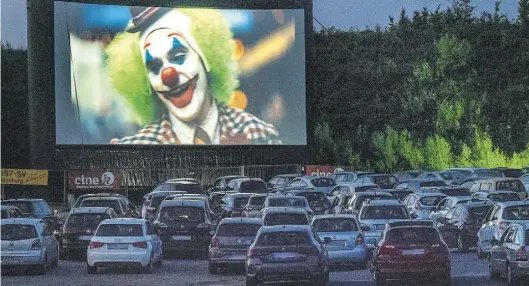  ?? BILD: SASCHA STÜBER ?? Filmvergnü­gen auf 130 Leinwand-Quadratmet­ern: Auf dem Freigeländ­e der Weser-Ems-Hallen sahen Zuschauer beim Autokino-Festival aus insgesamt 200 Autos den Premieren-Film „Joker“.