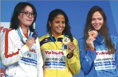  ?? MICHAEL DALDER / REUTERS ?? China’s Fu Yuanhui (silver), Brazilian Etiene Medeiros (gold) and Aliaksandr­a Herasimeni­a of Belarus (bronze) show off their 50m backstroke medals at the FINA World Aquatics Championsh­ips in Budapest, Hungary, on Thursday.