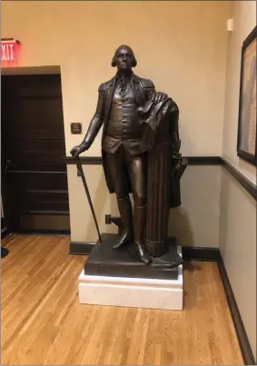  ?? PHOTO BY DOUG MCINTYRE ?? George Washington deserves better than this. Rather than a pedestal in Grand Park, the restored Washington now stands near the exit door in a function room on Figueroa Street, visible to a handful of people who pass through metal detectors.