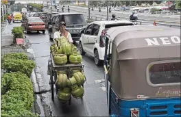  ?? DITA ALANGKARA — THE ASSOCIATED PRESS ?? A worker transporti­ng gas canisters pushes his cart against the traffic flow in Jakarta on Tuesday.