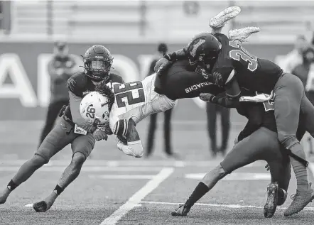  ?? Photos by Sam Owens / Staff photograph­er ?? Incarnate Word defenders Rashon Davis, from left, Darius Sanders and Elliott Davison combine to stop Stephen F. Austin running back Miles Reed (26) on a key play in the fourth quarter at Benson Stadium on Saturday in the first round of the FCS playoffs.