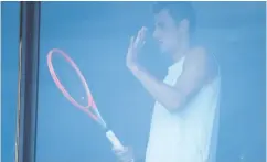  ?? WILLIAM WEST / AFP VIA GETTY IMAGES ?? Australian Bernard Tomic exercises in his hotel room in
Melbourne on Friday as players quarantine in hotels.