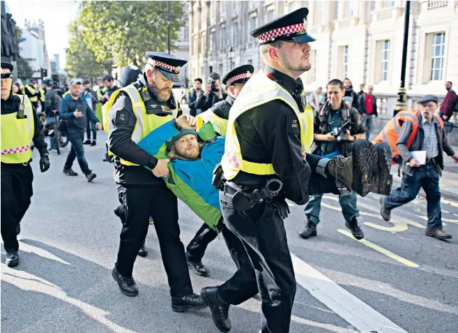  ??  ?? Police carry off an Extinction Rebellion protester in Whitehall during last month’s ‘Autumn Uprising’