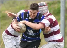  ??  ?? Owen Cardiff tries to burst past two Tullow opponents.