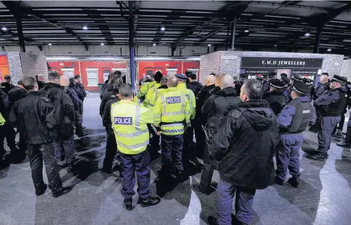  ??  ?? ●●Some of the officers on the Operation Challenger raids are briefed before entering the homes of suspected drug dealers