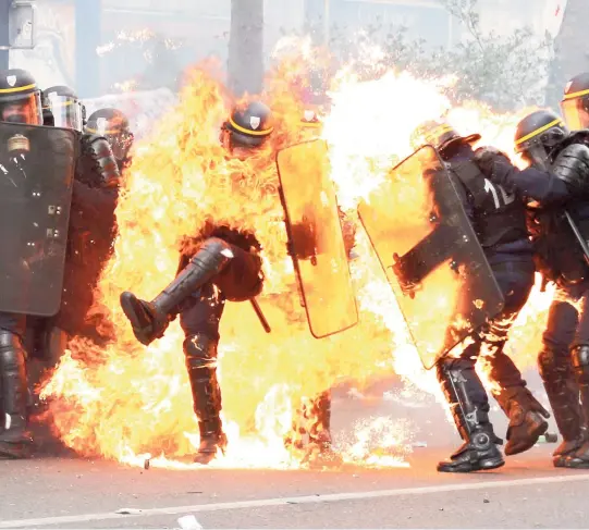  ??  ?? Des heurts entre des jeunes cagoulés et les forces de l’ordre ont éclaté lundi à Paris, blessant deux policiers, en marge du défilé du 1er mai. Des individus masqués et cagoulés ont jeté des projectile­s et des cocktails Molotov sur les forces de l’ordre.