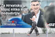  ?? REUTERS ?? A woman walks past a banner advertisin­g the campaign of Croatian Prime Minister Andrej Plenkovic on Saturday in Zagreb, Croatia.