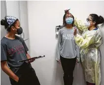  ?? Photos by Jon Shapley / Staff photograph­er ?? TOP: Animi Williams, 14, live-streams the action as her brother Adonye, 16, has his blood drawn by Tenea Johnson, a research assistant, at CyFair Clinical Research Center. Dylan Davis, above, 13, has her height measured by Anusha Abedin.