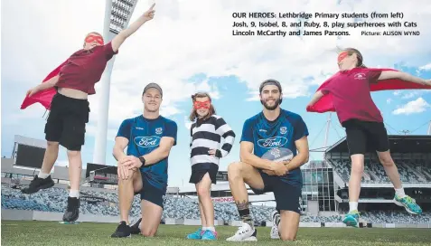  ?? Picture: ALISON WYND ?? OUR HEROES: Lethbridge Primary students (from left) Josh, 9, Isobel, 8, and Ruby, 8, play superheroe­s with Cats Lincoln McCarthy and James Parsons.