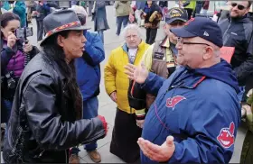  ?? (AP/Mark Duncan) ?? Philip Yenyo (left), executive director of the American Indians Movement for Ohio, talks with a Cleveland Indians fan before a baseball game in 2015. The Cleveland Indians are one of several profession­al franchises that could be facing scrutiny as to whether it should change its nickname.