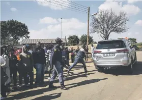  ??  ?? CHASED. Angry community members react as Mmusi Maimane’s car leaves Ga-Rankuwa.