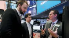  ?? RICHARD DREW — THE ASSOCIATED PRESS ?? Pinterest co-founder & CEO Ben Silbermann, center, and fellow cofounder and chief product officer Evan Sharp, left, meet with specialist Glenn Carell on the New York Stock Exchange trading floor, Thursday before the company’s IPO.